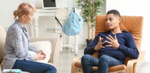 teenage boy speaking with female therapist 1170x574 1